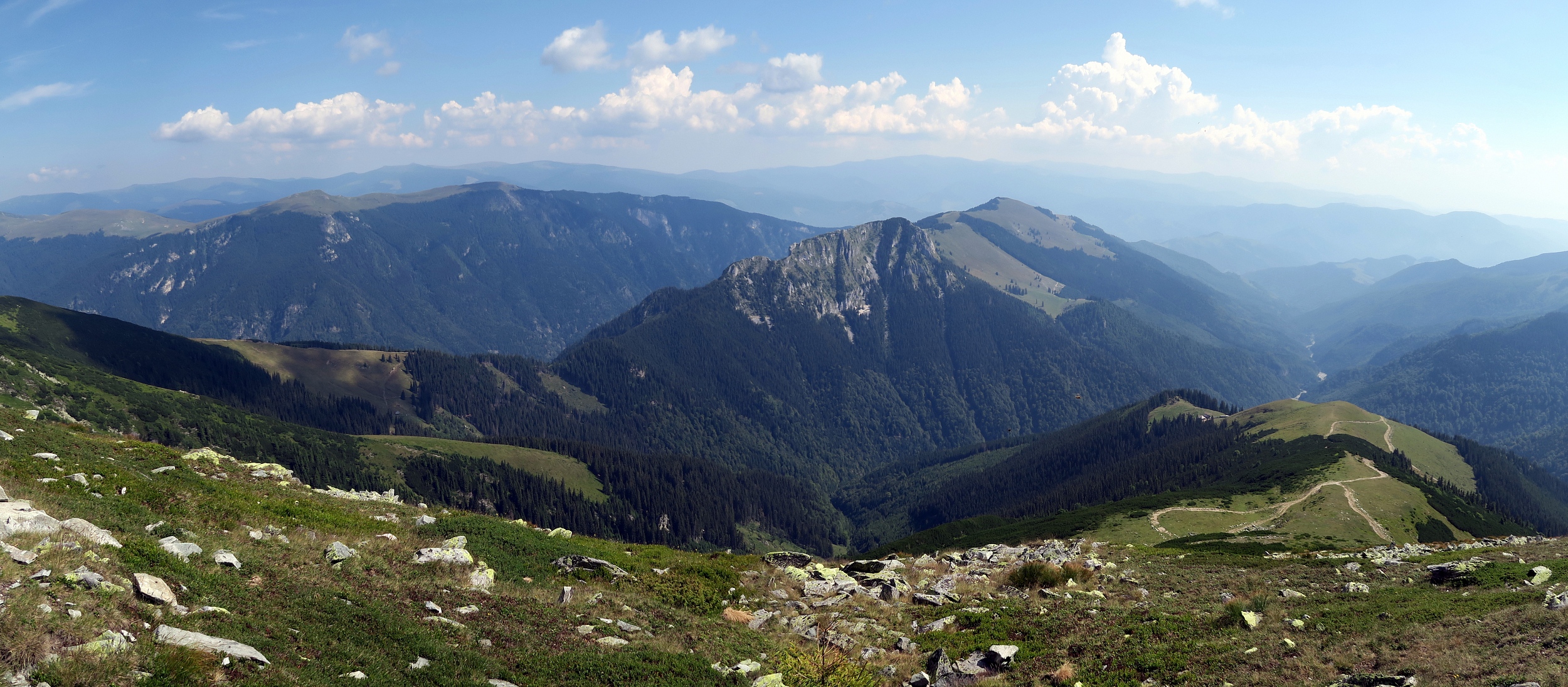 Munții Capatini / Panorama focené z nejvyššího vrcholu Nedeia. Vlevo od středu konec hřebene Latorita. Vpravo od středu vápencový hřeben Tirnovul (1847 m).